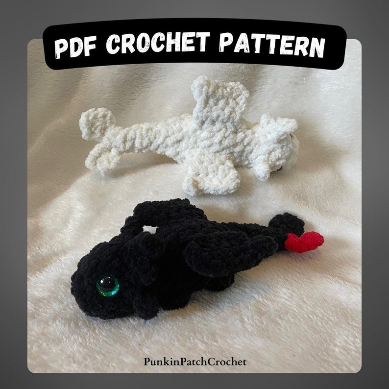 May include: PDF crochet pattern for two crocheted dragons, one white and one black. The white dragon is lying on its side with its wings spread out. The black dragon is lying on its belly with its wings folded. Both dragons have green eyes.
