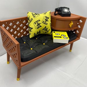 May include: Miniature brown bench with a black tufted seat and a yellow pillow patterned with black telephones. A small brown nightstand holds a black rotary phone and a yellow book labeled "Telephone Directory 1950."