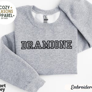 May include: Grey sweatshirt with the text "DRAMIONE" embroidered in black.