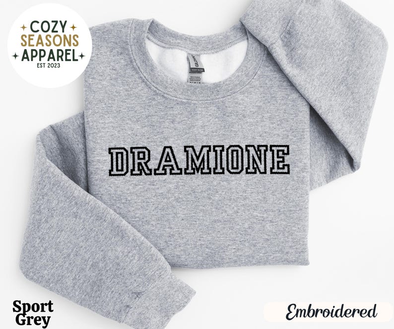 May include: Grey sweatshirt with the text "DRAMIONE" embroidered in black.