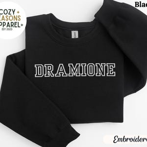 May include: Black sweatshirt with the text "DRAMIONE" embroidered in white.