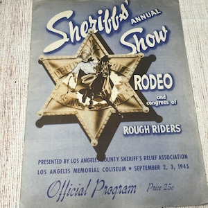 Peut inclure: Un programme officiel vintage de 1945 pour le Sheriff's Annual Show Rodeo and Congress of Rough Riders. La couverture bleue présente une grande étoile de shérif dorée avec un cow-boy à cheval, des détails sur l'événement au Los Angeles Memorial Coliseum et un prix de 25 cents.