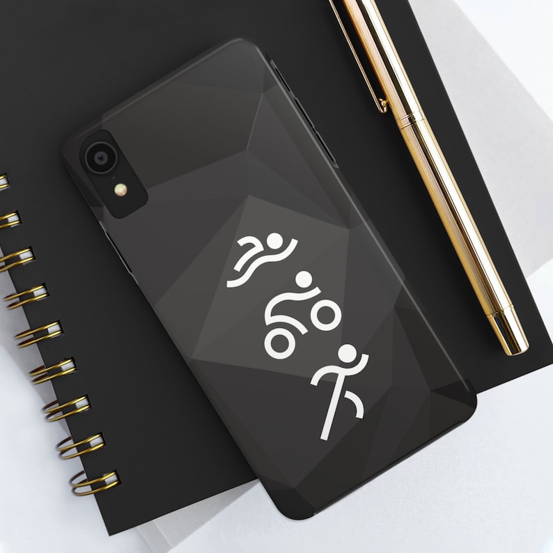 May include: A black smartphone case with a geometric, faceted surface texture. The back of the case features a white graphic print depicting three stylized figures representing swimming, cycling, and running in a vertical sequence.