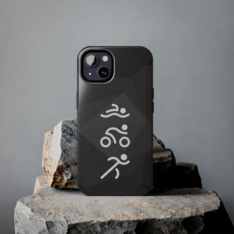 May include: A black smartphone case featuring a subtle geometric pattern and a white graphic design depicting three stylized figures in a vertical sequence representing swimming, cycling, and running, centered on the back of the device.