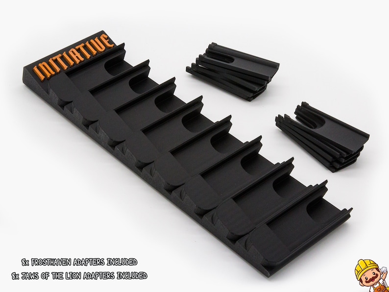 May include: A black plastic initiative tracker with orange text reading INITIATIVE, featuring eight slots for game cards. Included are two separate sets of eight black plastic adapters, labeled as Frosthaven and Jaws of the Lion adapters.