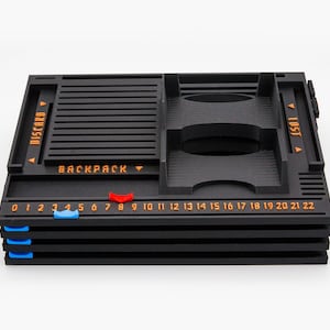 Pode incluir: Um organizador de jogos de tabuleiro preto com etiquetas de texto laranja lendo DISCARD, BACKPACK e LOST. A bandeja possui uma trilha numerada de 0 a 22 com um marcador deslizante vermelho e um azul, al&eacute;m de marcadores azuis nas laterais.