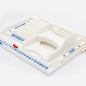 Pode incluir: Um organizador de tabuleiro de jogo em pl&aacute;stico branco com etiquetas de texto em azul, incluindo "DISCARD", "BACKPACK" e "LOST". O tabuleiro inclui uma pista numerada de 0 a 22, um compartimento central elevado e dois marcadores deslizantes em azul e vermelho.