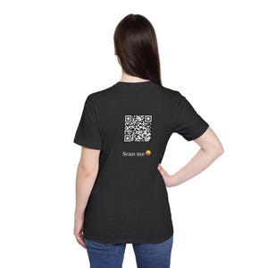 May include: A dark heather grey t-shirt with a black and white QR code on the back. The text "Scan me" and a smiling emoji are below the QR code.