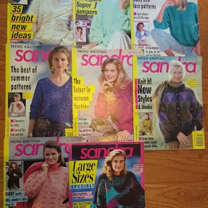 Könnte beinhalten: Eine Sammlung von acht Sandra Trend Knitting Magazinen mit verschiedenen Strickdesigns auf den Titelseiten. Jedes Cover zeigt Modelle in Pullovern, Strickjacken und Oberteilen mit Texten, die Titel, Ausgabedaten und Strickmuster-Highlights enthalten.