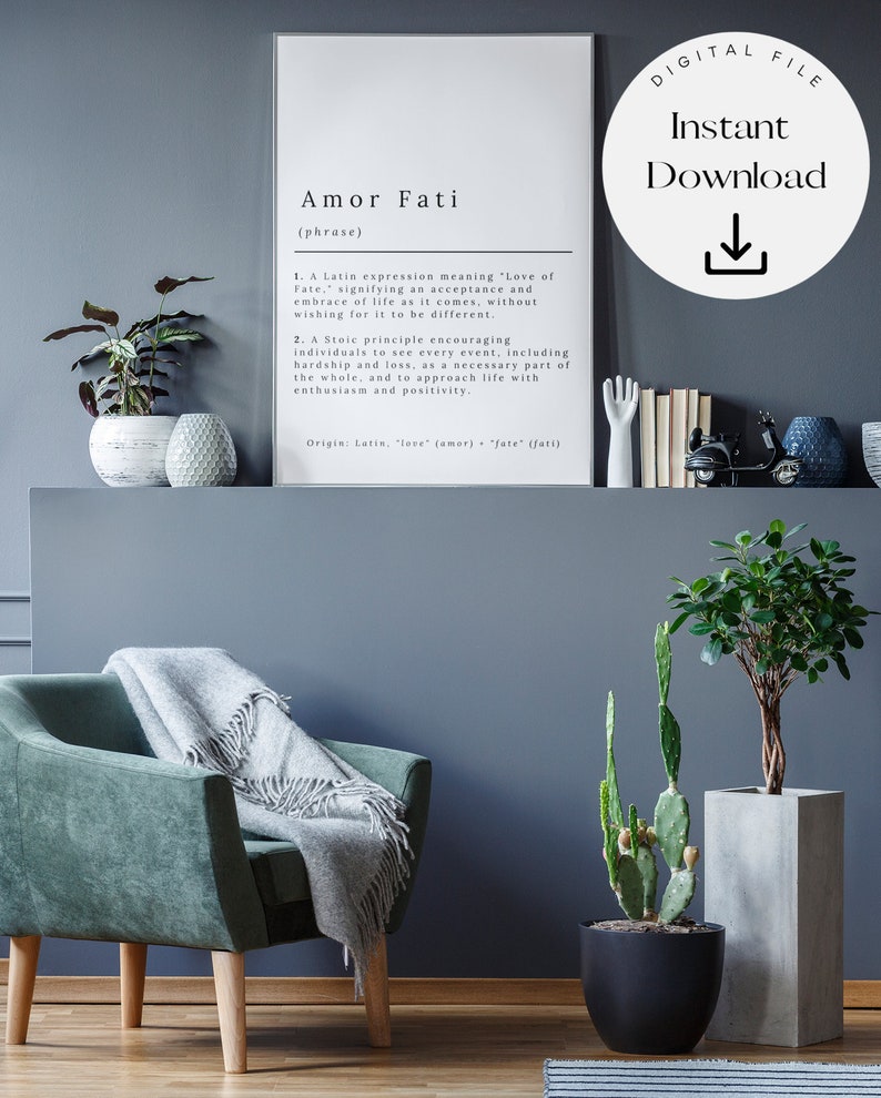 May include: A black and white printable poster with the Latin phrase "Amor Fati" defined as "Love of Fate". The poster is framed and hanging on a wall in a living room with a green armchair, a cactus, and a potted plant.
