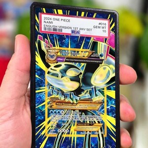 Pode incluir: Uma carta colecionável graduada pela PSA apresentando Primal Kyogre EX com uma borda preta. O rótulo no topo diz 2024 ONE PIECE NAMI #016 GEM MT 10. A carta exibe um gráfico azul e amarelo com o texto Primal Kyogre EX, Tidal Storm e 240 HP.