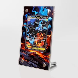 Könnte beinhalten: Gerahmte Sammelkarte mit einem schwarzen und orangefarbenen Wesen mit blauen Flammen. Die Karte wird in einem transparenten Acrylrahmen mit einem silbernen Ständer präsentiert. Der Hintergrund hat ein feuriges, lavaartiges Design.