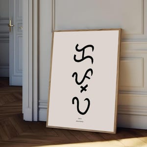 May include: A framed art print with abstract black shapes on a pale beige background. The print includes the text "lapwa shared identity" at the bottom. The frame is a natural wood colour, leaning against a white wall.