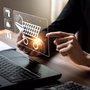 May include: A person's hand interacting with a digital shopping cart icon, representing online shopping. The image includes a laptop, a calculator, and other e-commerce related icons. The scene is set on a wooden desk.