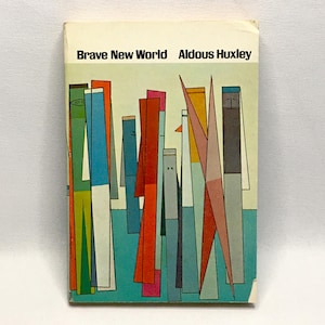 May include: A paperback book titled Brave New World by Aldous Huxley. The cover features a light blue background with a graphic illustration of abstract, tall, thin, multi-colored geometric shapes in shades of orange, blue, grey, and pink.