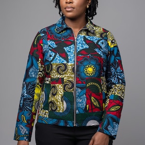 May include: A long-sleeve jacket featuring a vibrant patchwork design with various floral and geometric patterns in shades of red, blue, yellow, and green. The jacket has a classic collar, a full-length front metal zip, and long sleeves.