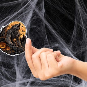 May include: A die-cut sticker featuring a dark, furry werewolf howling at a large, glowing orange full moon. The scene includes a silhouette of a forest, two glowing jack-o'-lanterns in the foreground, and small bats flying in the night sky.