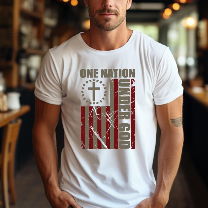 May include: White t-shirt with a distressed American flag design and the text "ONE NATION UNDER GOD." The flag includes a cross within a circle of stars. The shirt has a crew neck and short sleeves.