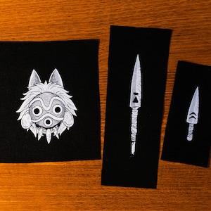 May include: Three black patches with white illustrations. One shows a wolf-like creature's face, the others depict stylized knives or spears. The designs are detailed and artistic, suitable for patches or appliques.