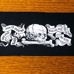 Memento Mori. Cráneo, huesos y estandarte con texto. Xilografía medieval. Parche serigrafiado.