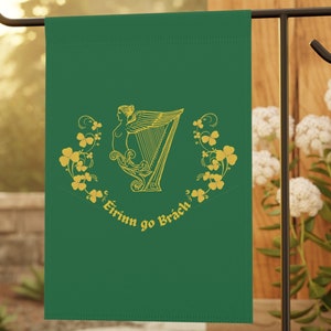 May include: A green garden flag featuring a gold harp with a woman playing it. The text "Eirinn go Brach" is written below the harp.