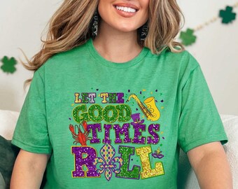 May include: A green t-shirt with a glittery design that says "Let the good times roll". The design includes a trumpet, a fleur-de-lis, and a crawfish.