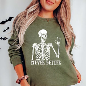 May include: A green sweatshirt with a white skeleton graphic and the text "NEVER BETTER".
