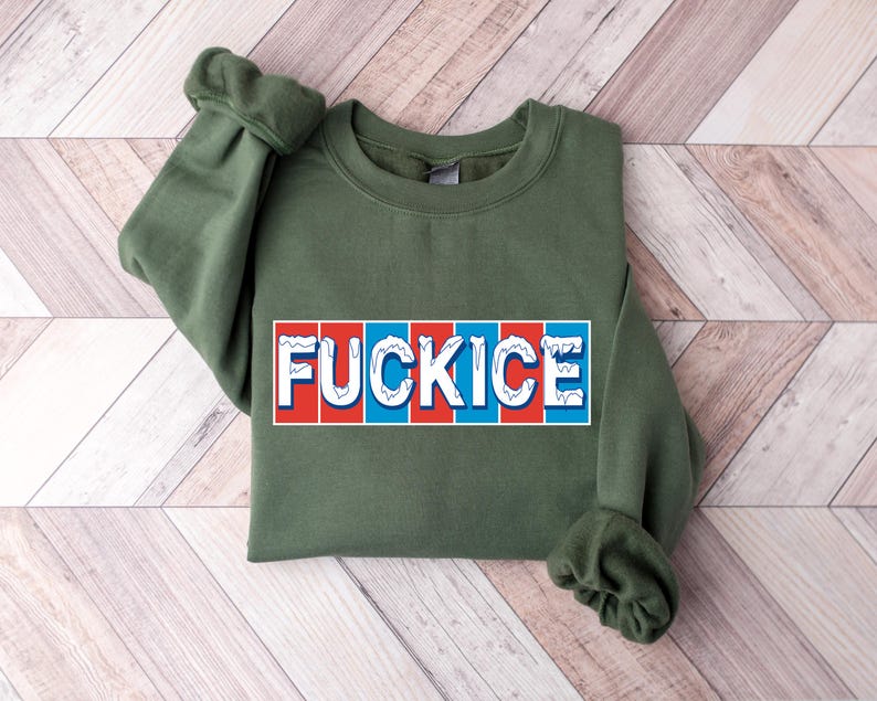 以下が含まれることがあります： 胸に「FUCKICE」の文字が長方形のデザインでプリントされたオリーブグリーンのスウェットシャツ。テキストは白で、赤と青の縦縞模様。袖口は折り返されています。