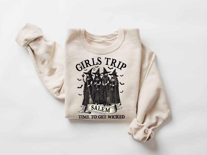 May include: A beige sweatshirt with a black graphic print of four witches with the text "Girls Trip Salem Time to Get Wicked".