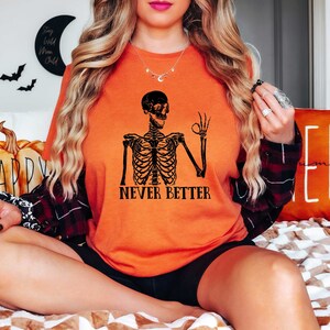 May include: Orange t-shirt with a black skeleton graphic and the text "Never Better".