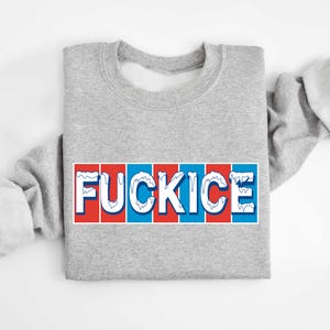 以下が含まれることがあります： 大胆で様式化されたフォントで「FUCKICE」という言葉が書かれた、ヘザーグレーのスウェットシャツ。テキストは白で、青と赤のアクセントがあり、長方形のデザインになっています。スウェットシャツは長袖です。