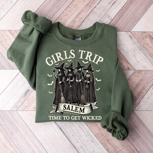 May include: Green sweatshirt with a graphic of four witches and the text "Girls Trip Salem Time to Get Wicked".