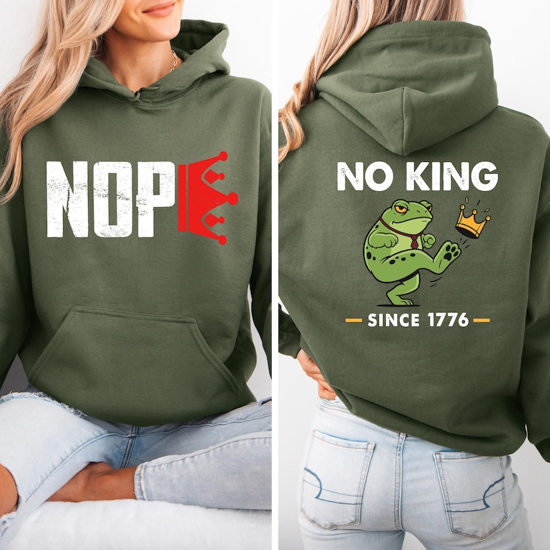 May include: An olive green hoodie with the word "NOPE" in white block letters and a red crown graphic. The back of the hoodie features the text "NO KING" above a cartoon frog kicking a crown, with "SINCE 1776" below.