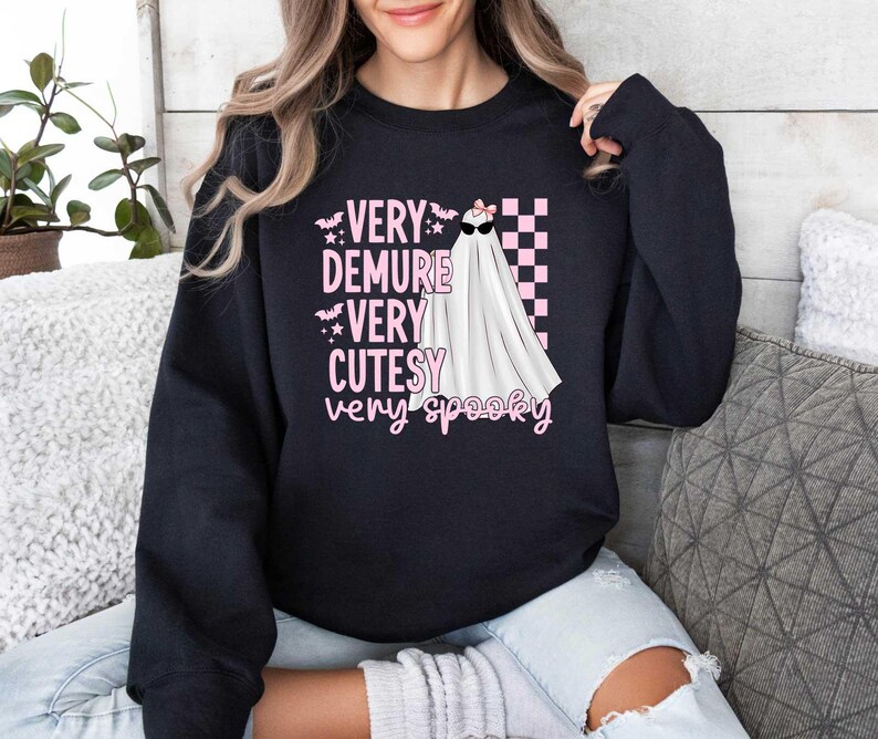 May include: Black sweatshirt with a pink graphic of a ghost with the text "Very Demure Very Cutesy Very Spooky"