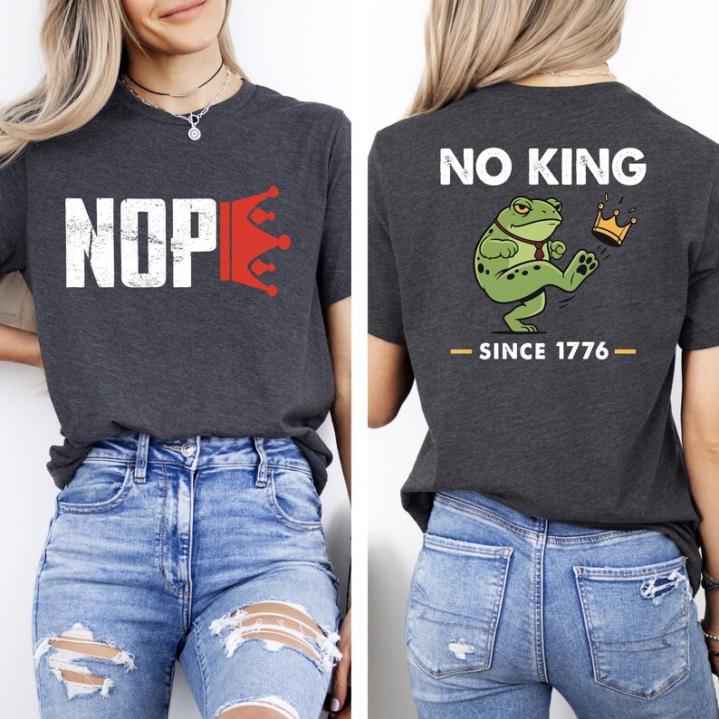 May include: Dark gray t-shirt with the word "NOP" in white and a red crown graphic. The back of the shirt features a green frog with a crown and the text "NO KING - SINCE 1776".