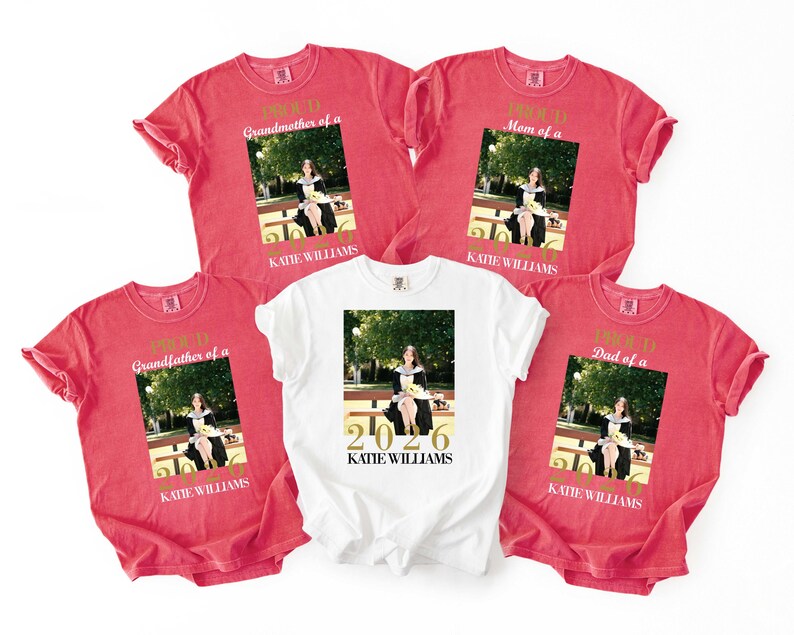 May include: Red and white t-shirts with a photo of a person in a graduation gown. The red shirts say "Proud Grandmother of a," "Proud Mom of a," "Proud Grandfather of a," and "Proud Dad of a." The white shirt says "2026 KATE WILLIAMS."