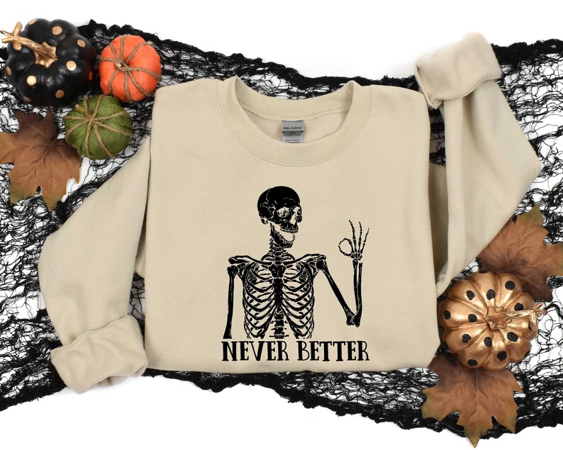 May include: A tan sweatshirt with a black skeleton graphic and the text "NEVER BETTER".