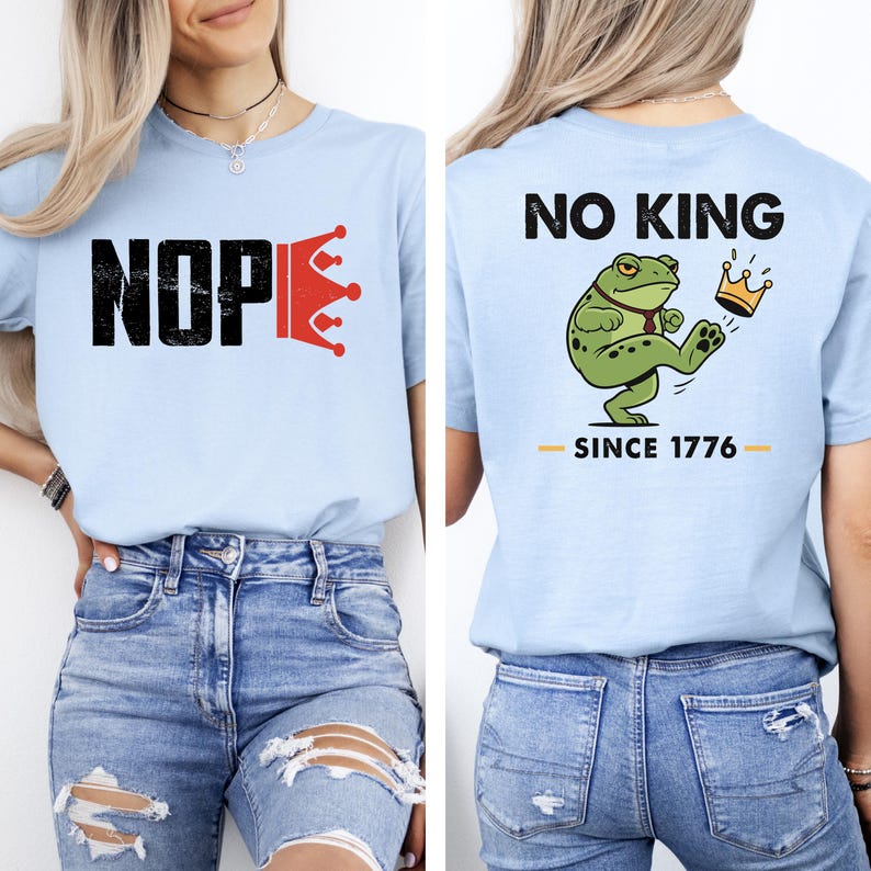 May include: Light blue t-shirt with the word "NOPE" in black block letters and a red crown graphic. The back of the shirt features a green frog kicking a crown with the text "NO KING SINCE 1776".