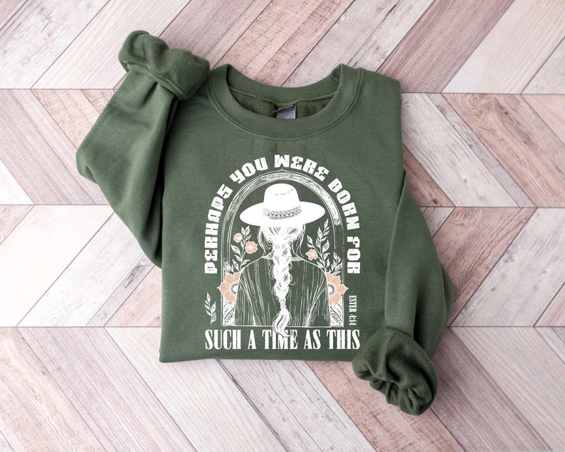 May include: Green sweatshirt with a white graphic print of a woman wearing a hat and the text "Perhaps you were born for such a time as this" and the reference "Esther 4:14".