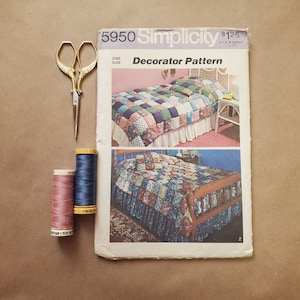 May include: A Simplicity sewing pattern for a quilt, pattern number 5950, titled "Decorator Pattern". The pattern is for one size and costs $1.25. The pattern shows two images of a bed with a patchwork quilt.