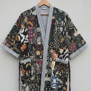 May include: A patterned patchwork robe with a black base, featuring floral and animal motifs. It has a striped trim and a matching belt. The text "Jackets Robes Dresses" is visible at the bottom of the image.