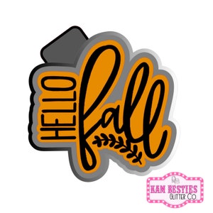 Puede incluir: Cortador de galletas naranja y negro con las palabras "Hello Fall" y un diseño de hoja estilizado.