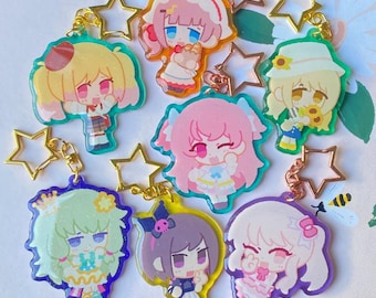 May include: A collection of colorful anime-style character keychains. Each keychain features a unique character design with vibrant colors, attached to a gold-colored chain and star-shaped charm. The characters have different hairstyles and outfits.