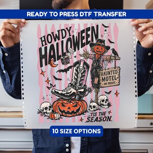 May include: A Ready to Press DTF transfer sheet featuring a Howdy Halloween graphic with a scarecrow, cowboy boot, pumpkins, skulls, and a Haunted Motel sign. The design includes bats, stars, and the text Tis the Season on a pink striped background.