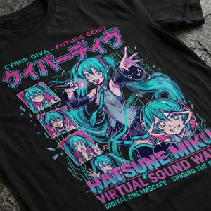 May include: Black t-shirt featuring a vibrant anime-style illustration of a character with turquoise hair, holding a microphone. The design includes Japanese text and the words "Hatsune Miku" and "Virtual Sound Wave."