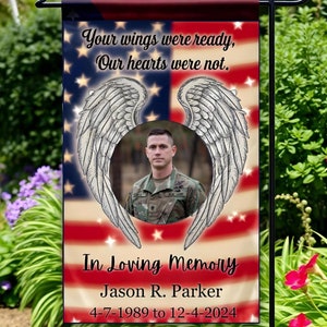 May include: A memorial garden flag with a photo of a man in military uniform. The flag features an American flag design with angel wings and the text "Your wings were ready, Our hearts were not."  The text "In Loving Memory Jason R. Parker 4-7-1989 to 12-4-2024" is printed below the photo.