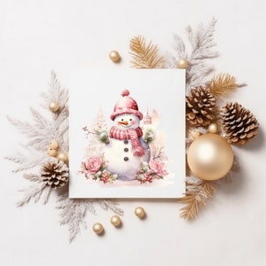May include: A festive watercolour illustration of a snowman wearing a pink hat and scarf, surrounded by winter foliage and ornaments. The snowman has a carrot nose and button eyes. The image is set against a white background with gold and silver accents, creating a holiday theme.
