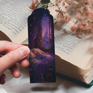 Può includere: Un segnalibro con una scena fiabesca di una persona addormentata in un letto, con un castello sullo sfondo. Il segnalibro ha un bordo viola scuro con una forma ad arco gotico. La scena è piena di sfumature di viola, rosa e oro.