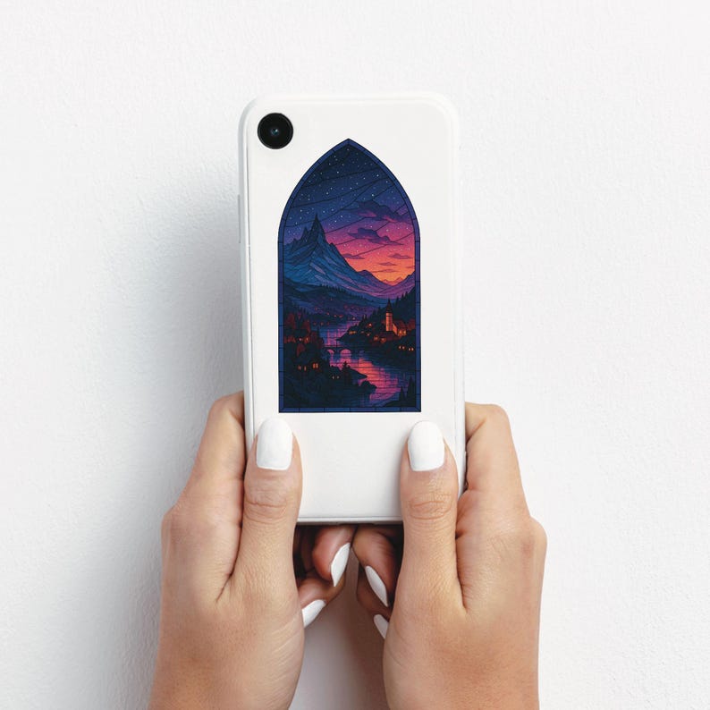 May include: A white phone case featuring a stained-glass style illustration of a mountain landscape at sunset. The design includes a river, buildings, and a starry sky, all within an arched frame.