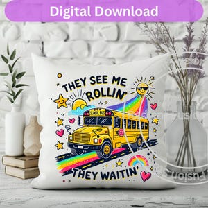 May include: White pillow with a yellow school bus illustration and the text "They see me rollin' They waitin'" in colorful letters. The bus has a rainbow behind it and stars and hearts around it.